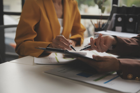 business women pointing at reports